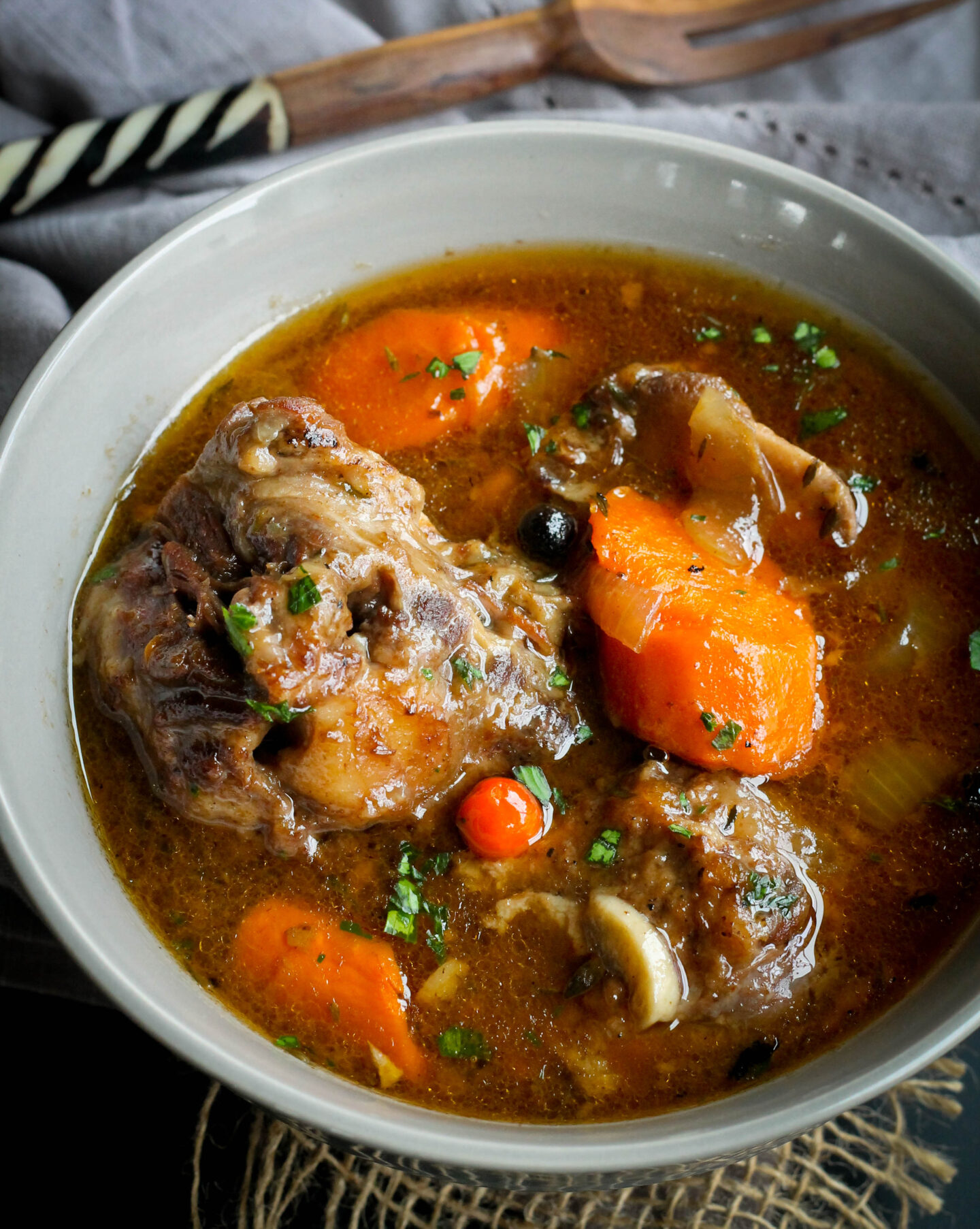 slowcooker oxtail in a bowl over head shot with spoon