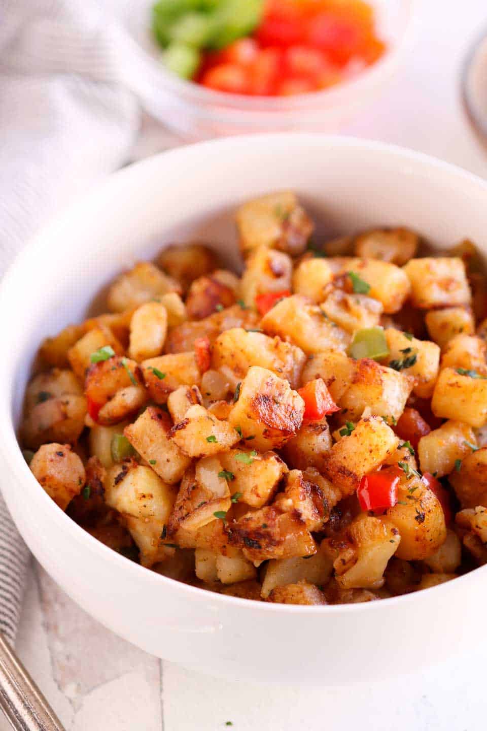 diced potatoes cooked until crispy with peppers, onions and spices and served in a white bowl