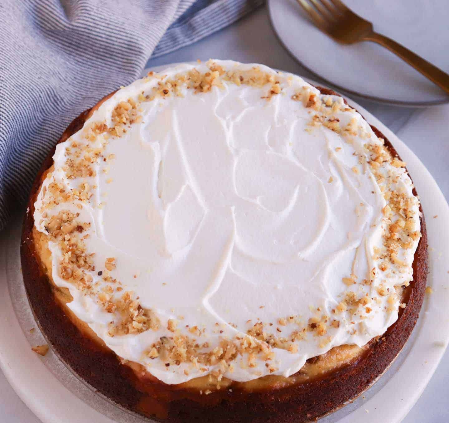 a whole carrot cake cheesecake topped with cheesecake and nuts.