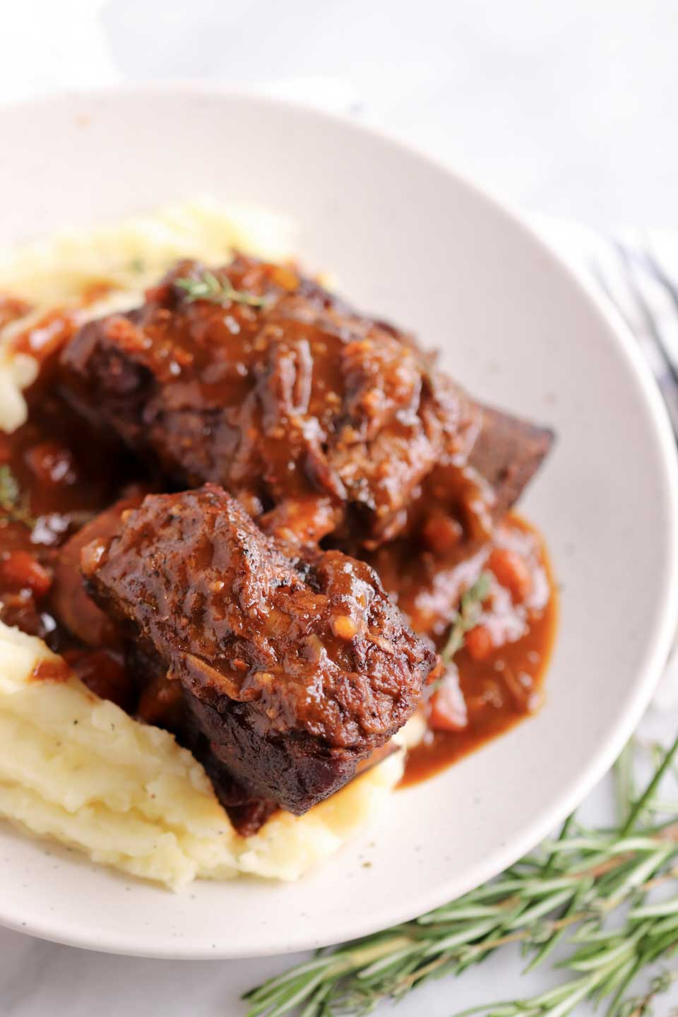 upclose image of slow cooked ribs in a bowl with mashed potatoes