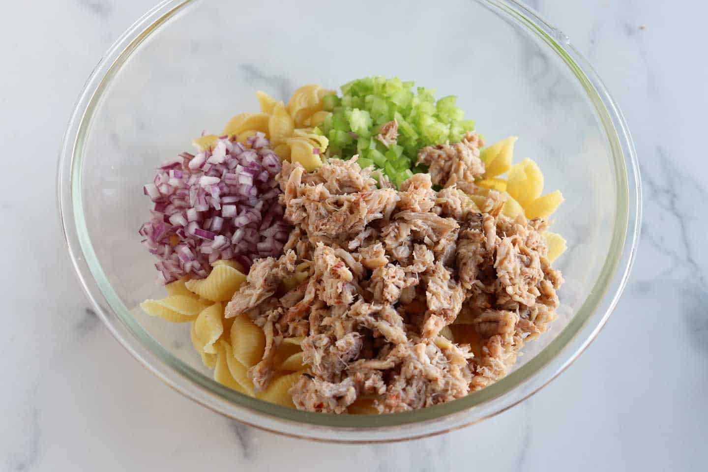 crab, red onion, celery and pasta shell in a bowl