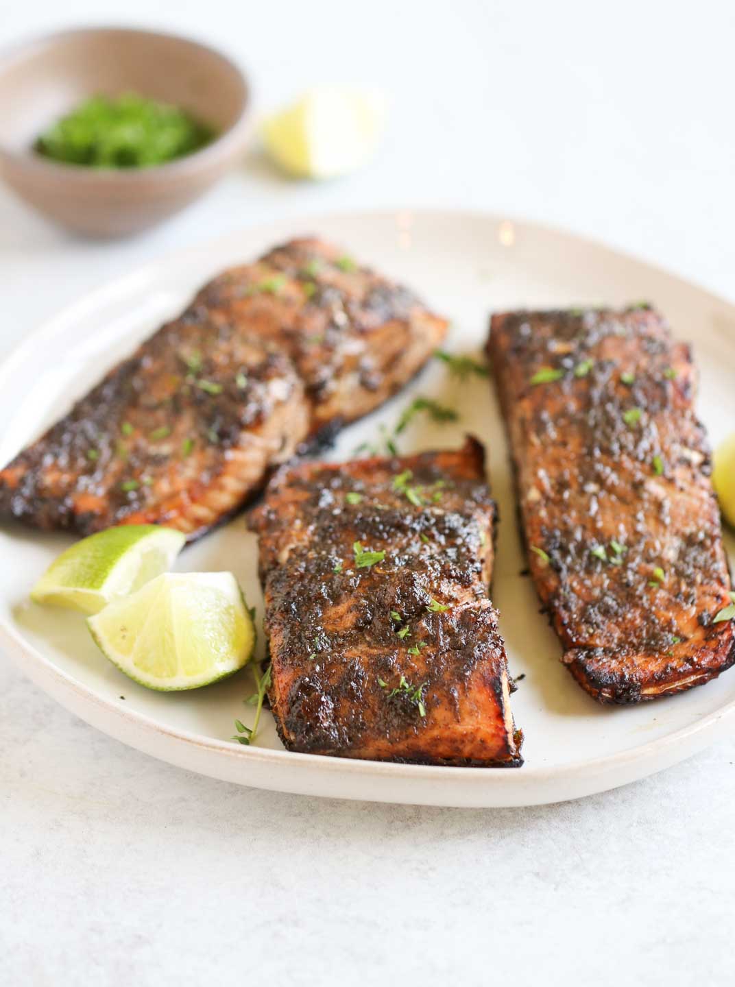 Air fryer jerk salmon fillets topped with fresh herbs
