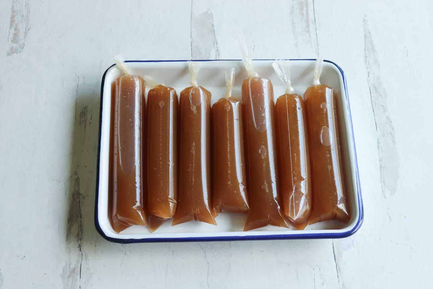 A stack of tamarind ice pops on a white tray ready to be frozen
