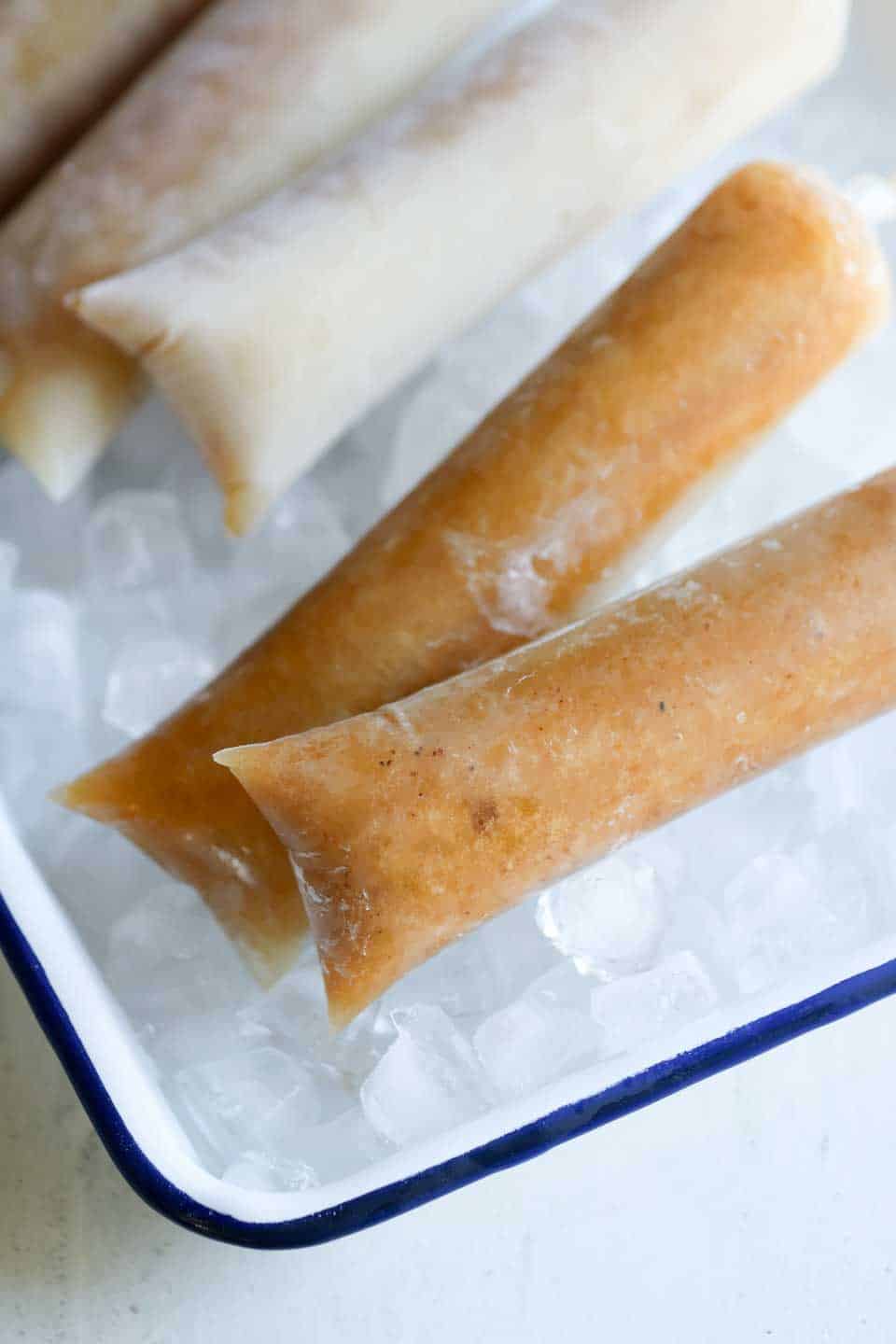 "Several tamarind ice pops laid out on a bed of crushed ice, keeping them cool and refreshing, perfect for a hot day